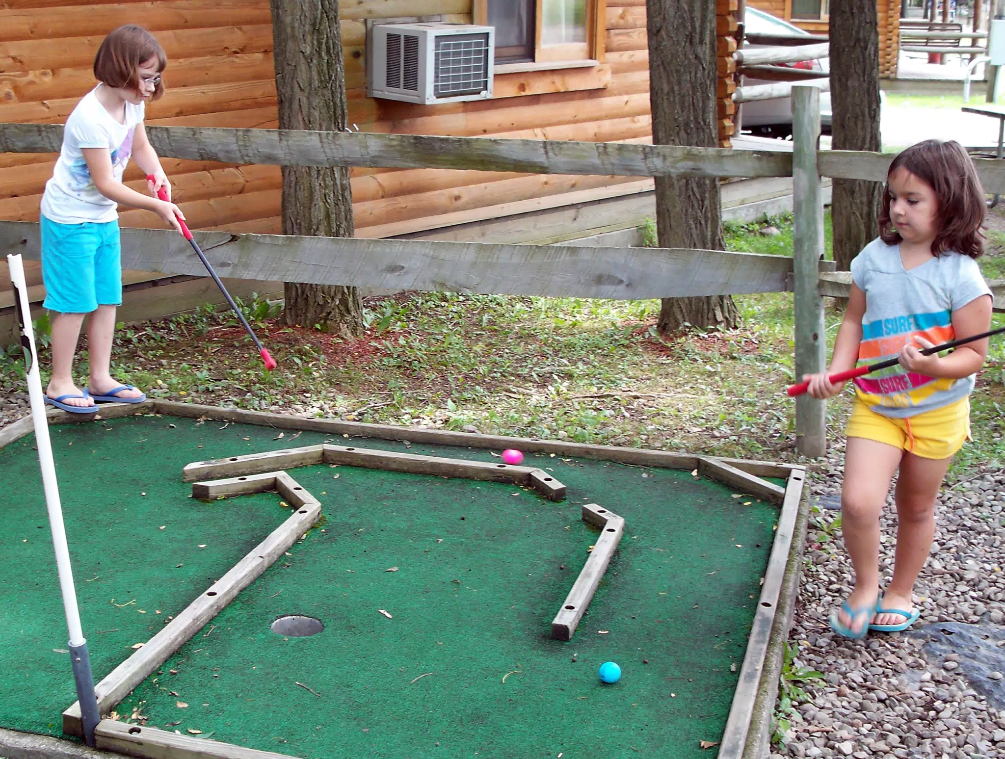 Madeline and Emily Playing Miniature Golf