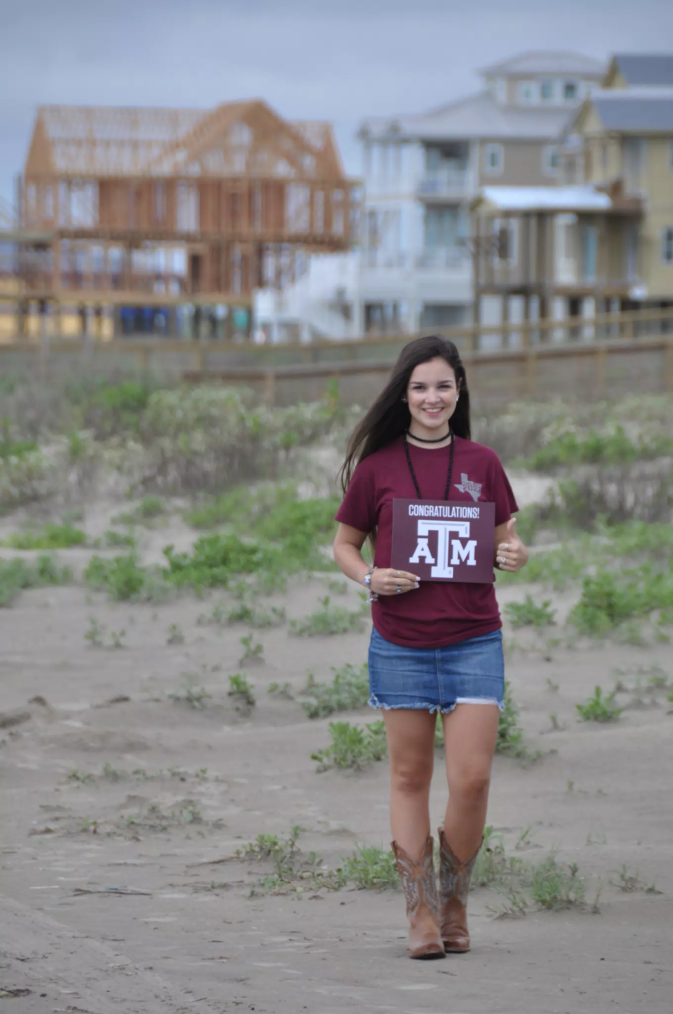 Emily Grice with Aggies Sign on Galveston Beach