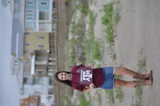 Emily with Aggies Sign on Galveston Beach