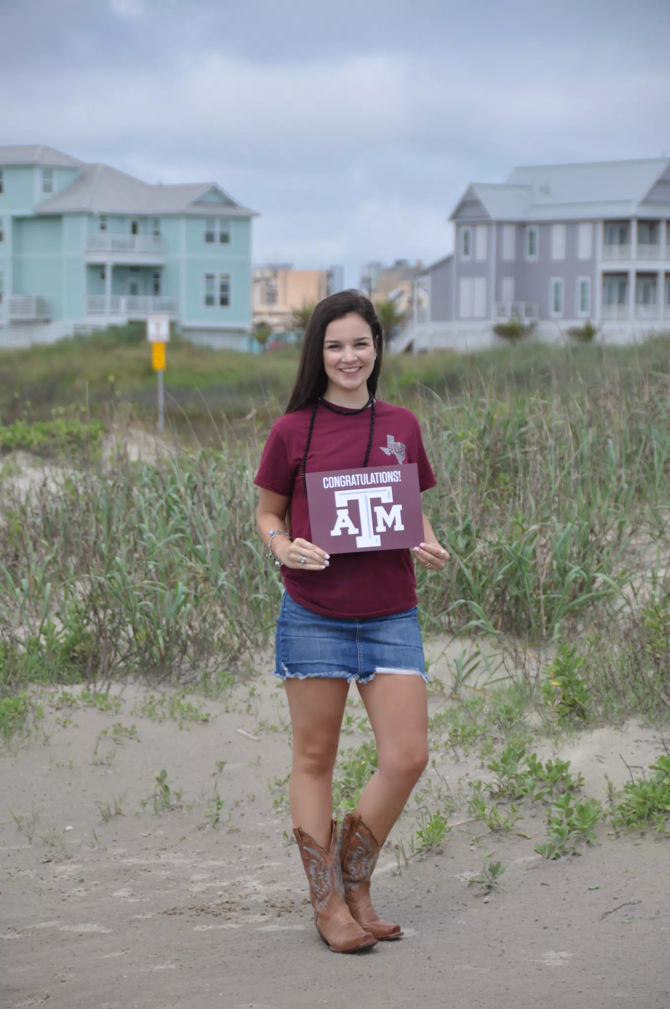 Emily with Aggies Sign on Galveston Beach