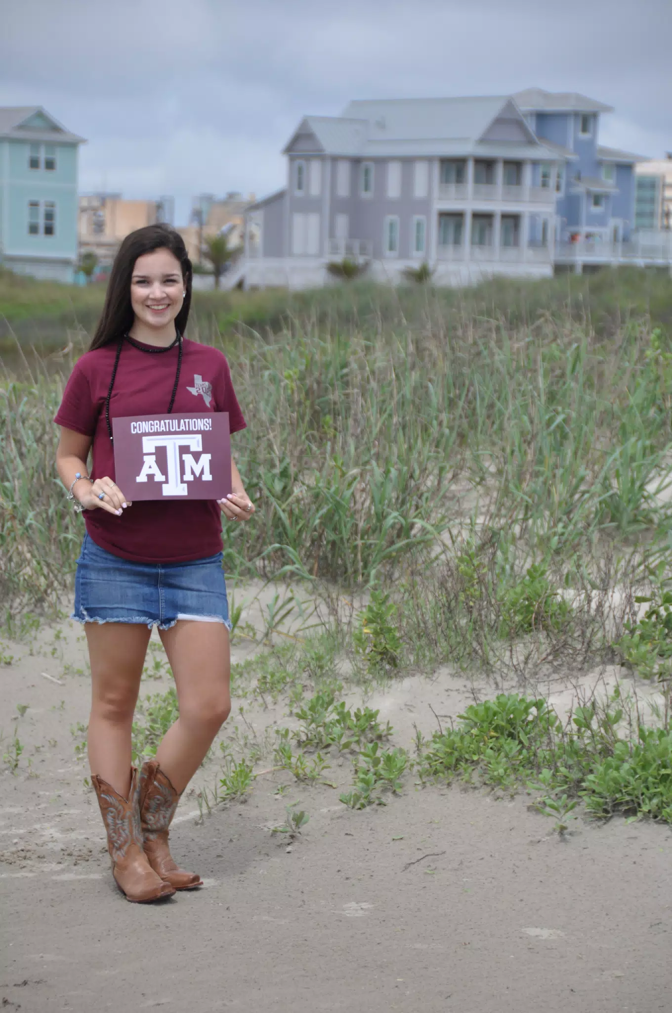 Emily with Aggies Sign on Galveston Beach