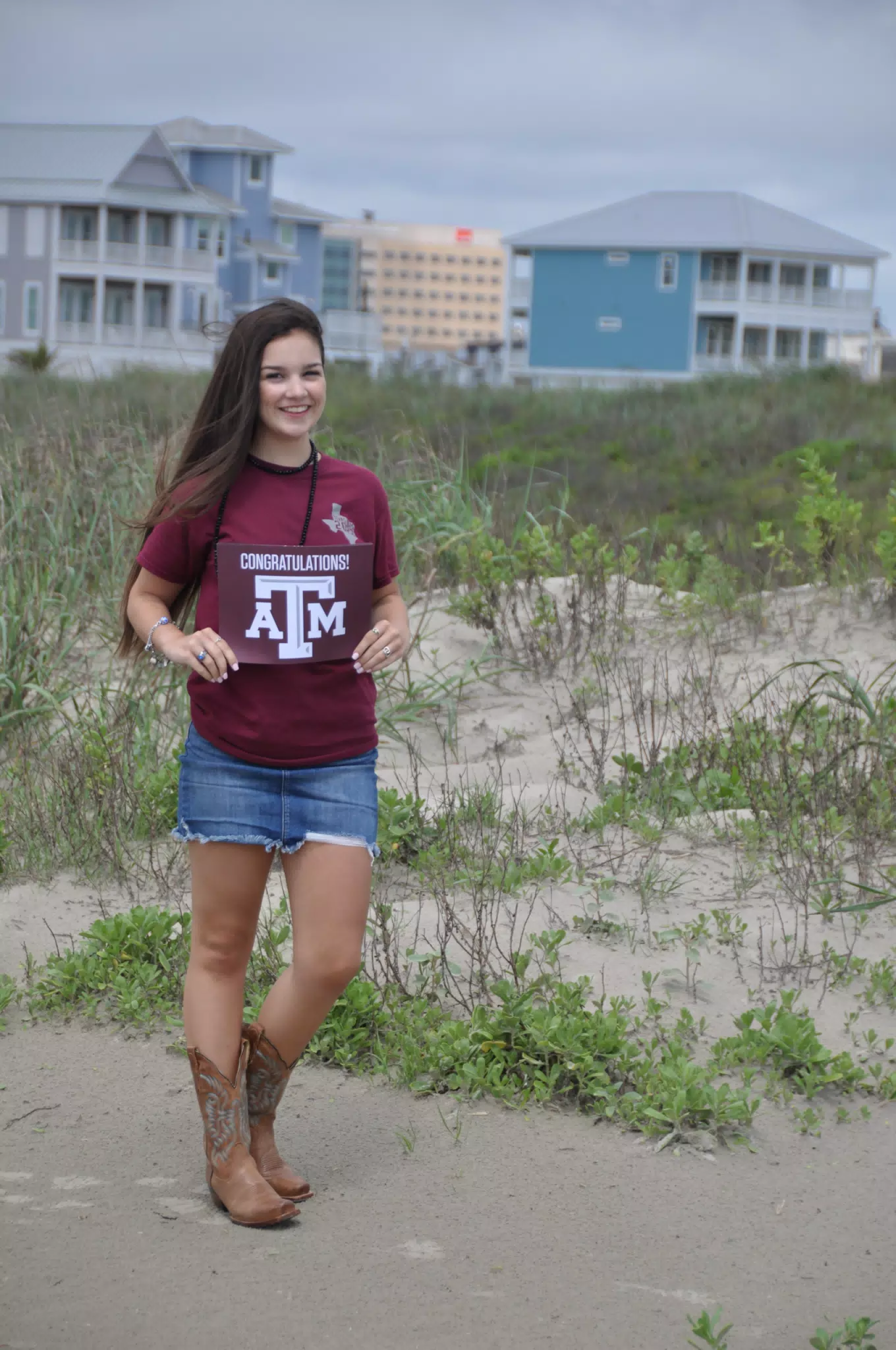 Emily with Aggies Sign on Galveston Beach