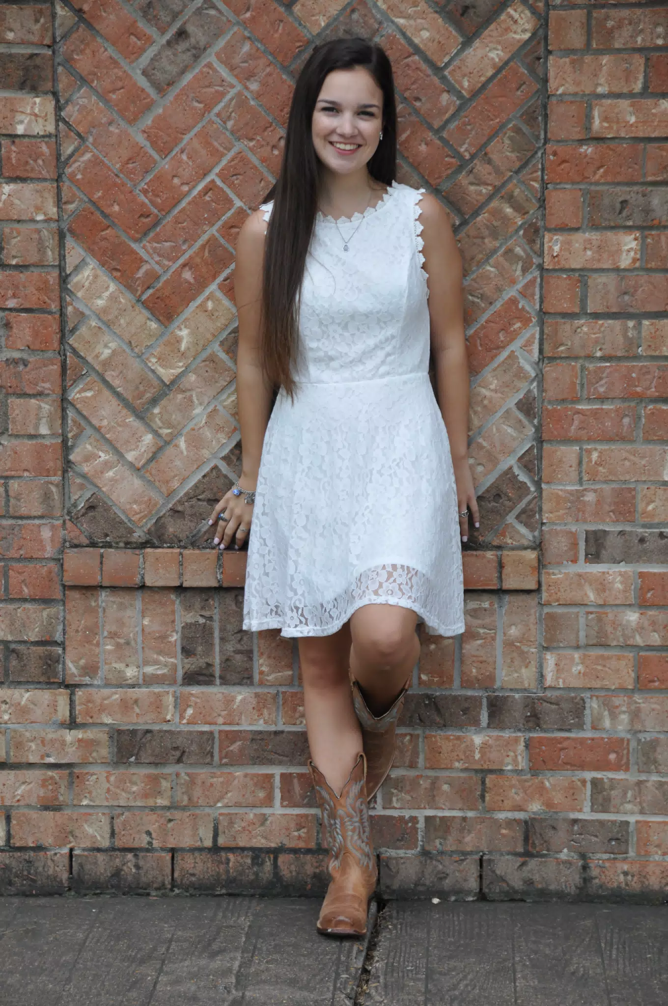 Model in White Dress Against Brick Wall, Cowgirl Boots