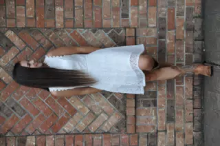 Cowgirl Model in White Dress with Boots on Brick Wall in Texas