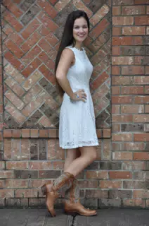 Teen Model in White Dress by Brick Wall in Boots