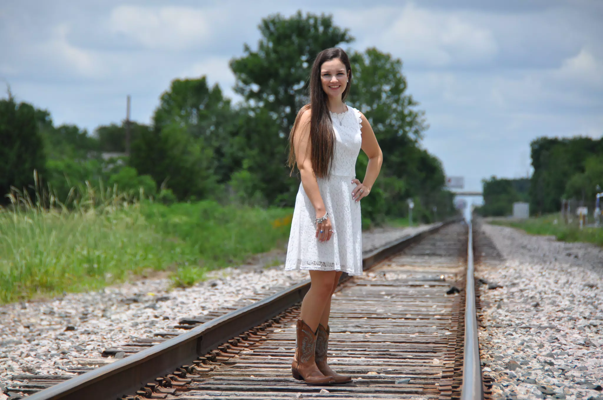 Teen Model on Railroad Tracks in White Dress and Cowboy Boots on Sunny Day in Texas