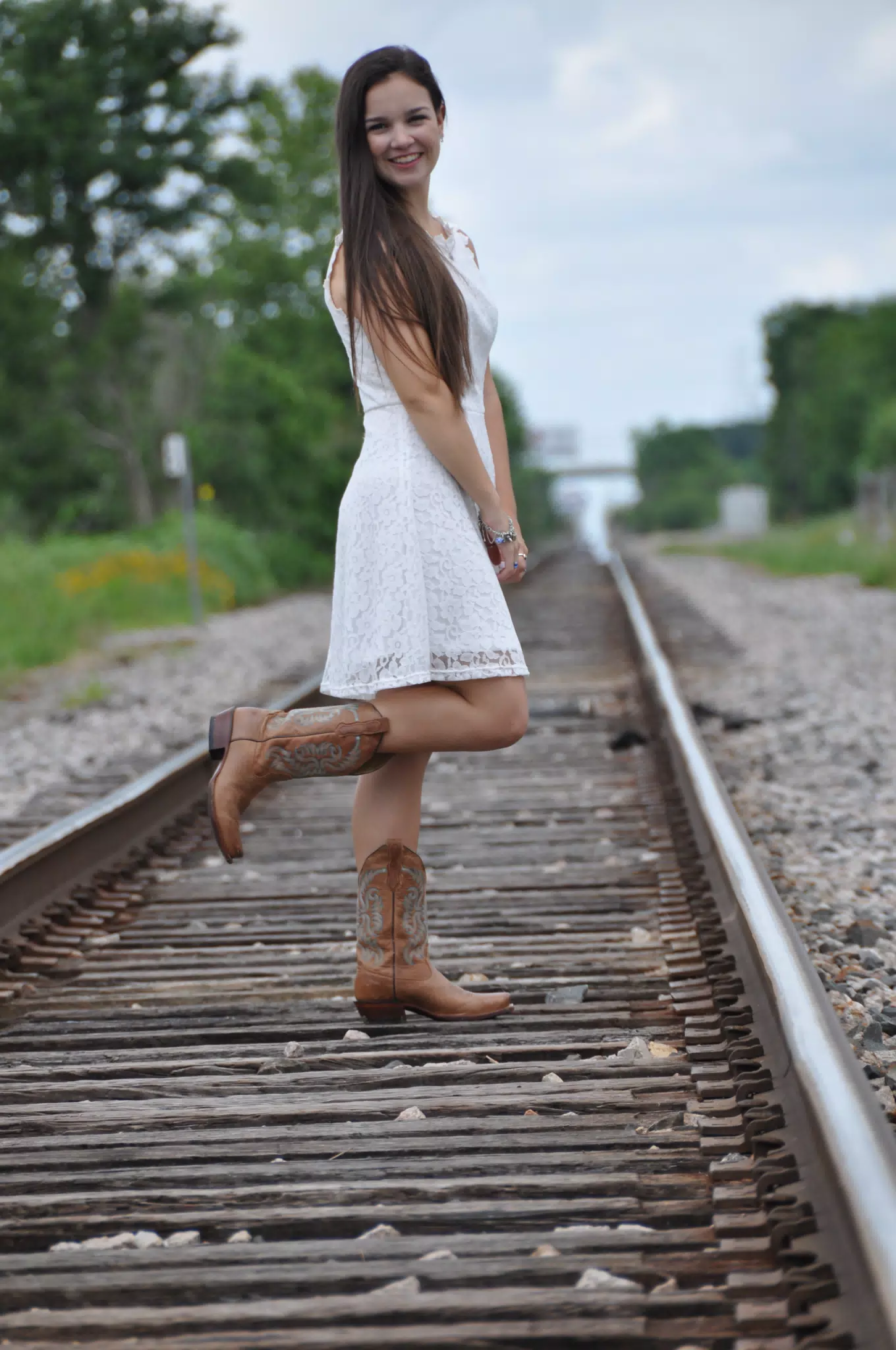Young Brunette Model in White Dress & Cowgirl Boots on Railroad Tracks in Texas