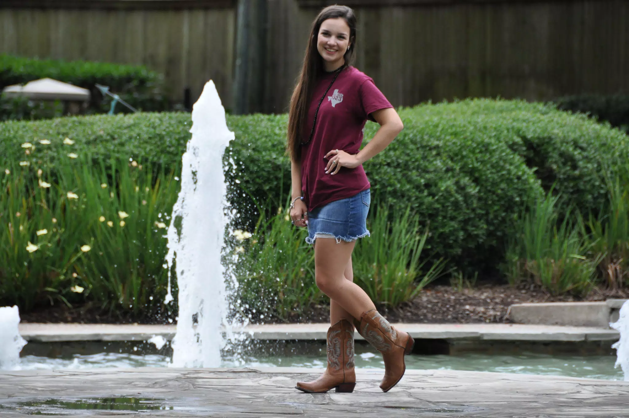 Model in Miniskirt by Fountain in Cowgirl Boots