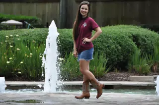 Model in Miniskirt by Fountain in Cowgirl Boots