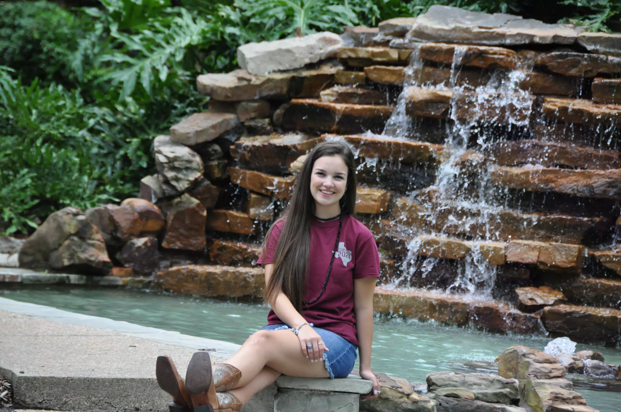 Emily Sitting in Front of Waterfall in Boots and Skirt