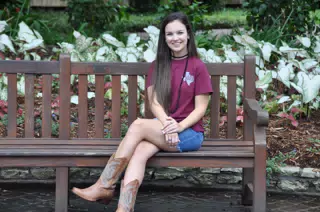 Emily on Park Bench in Jean Skirt and Cowgirl Boots