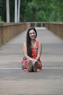 Emily Sitting on Boardwalk Over Pond in Texas in Red Dress