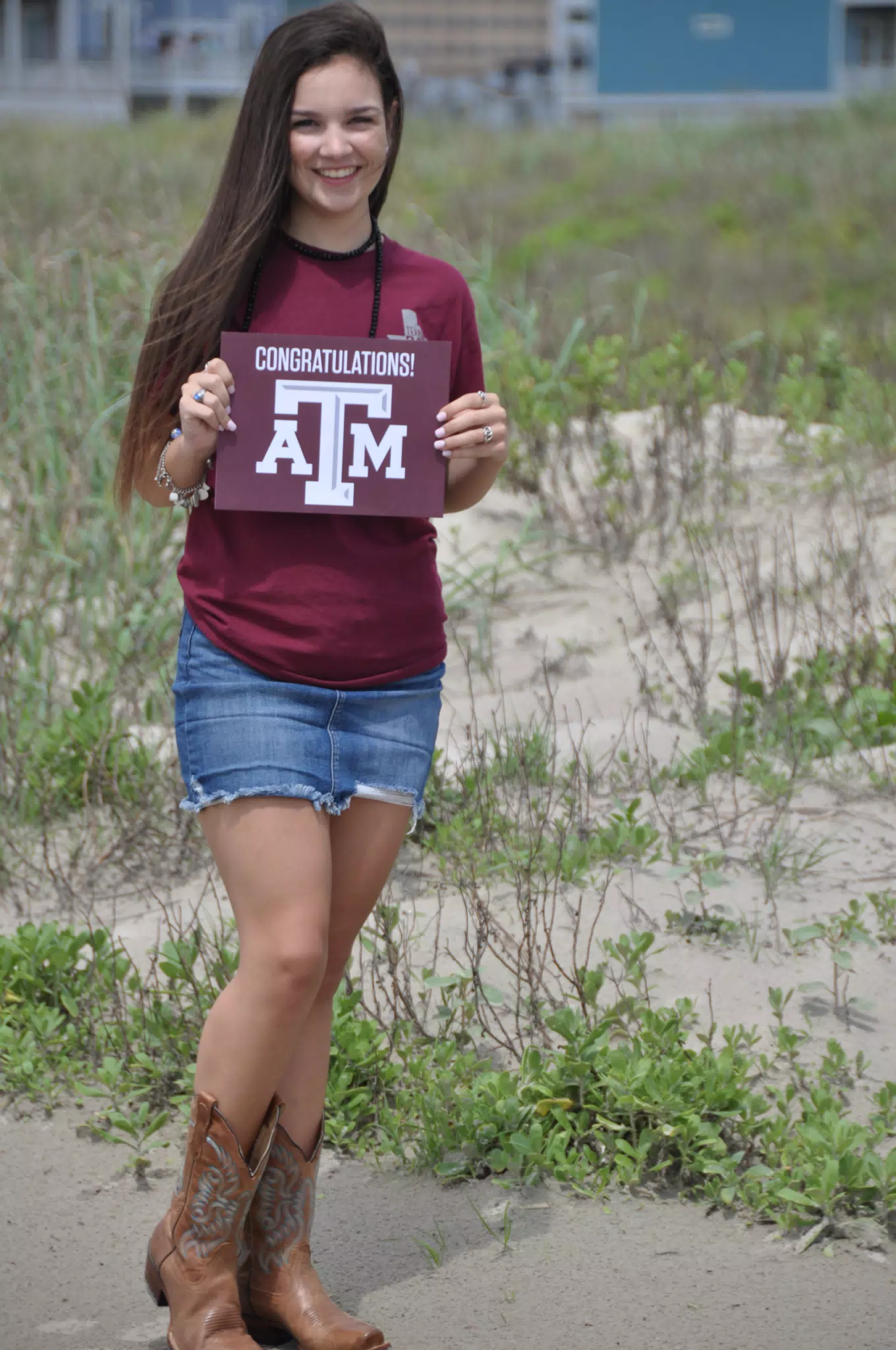 Emily Holding Aggies Sign on Galveston Beach