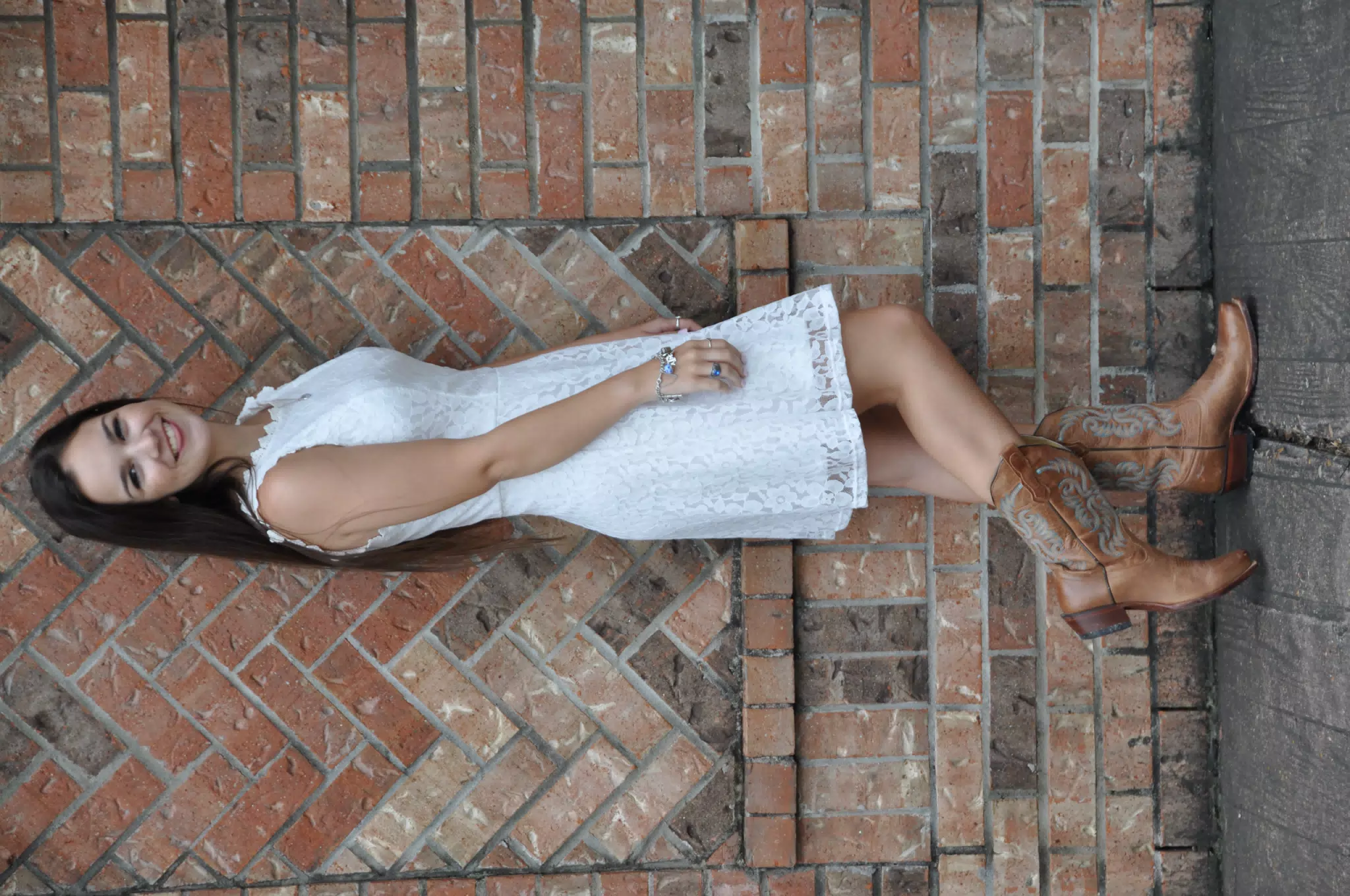 Model in White Dress with Tongue Out by Brick Wall