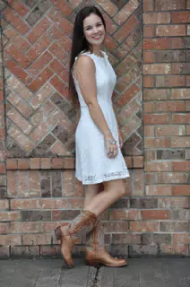 Model in White Dress with Tongue Out by Brick Wall