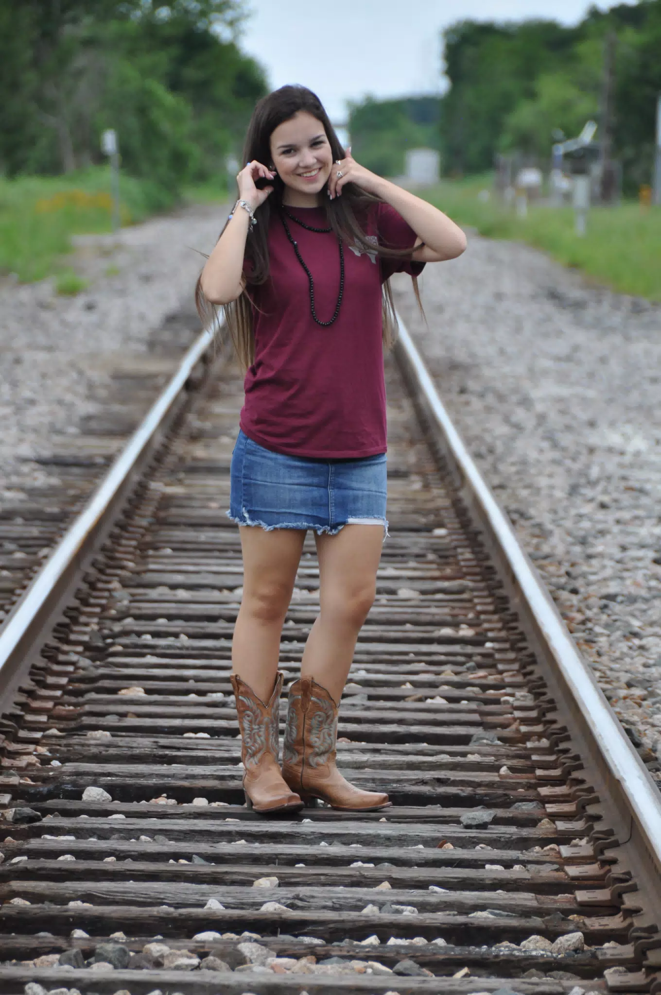 Emily on Railroad Tracks in Cowgirl Boots and Jean Skirt