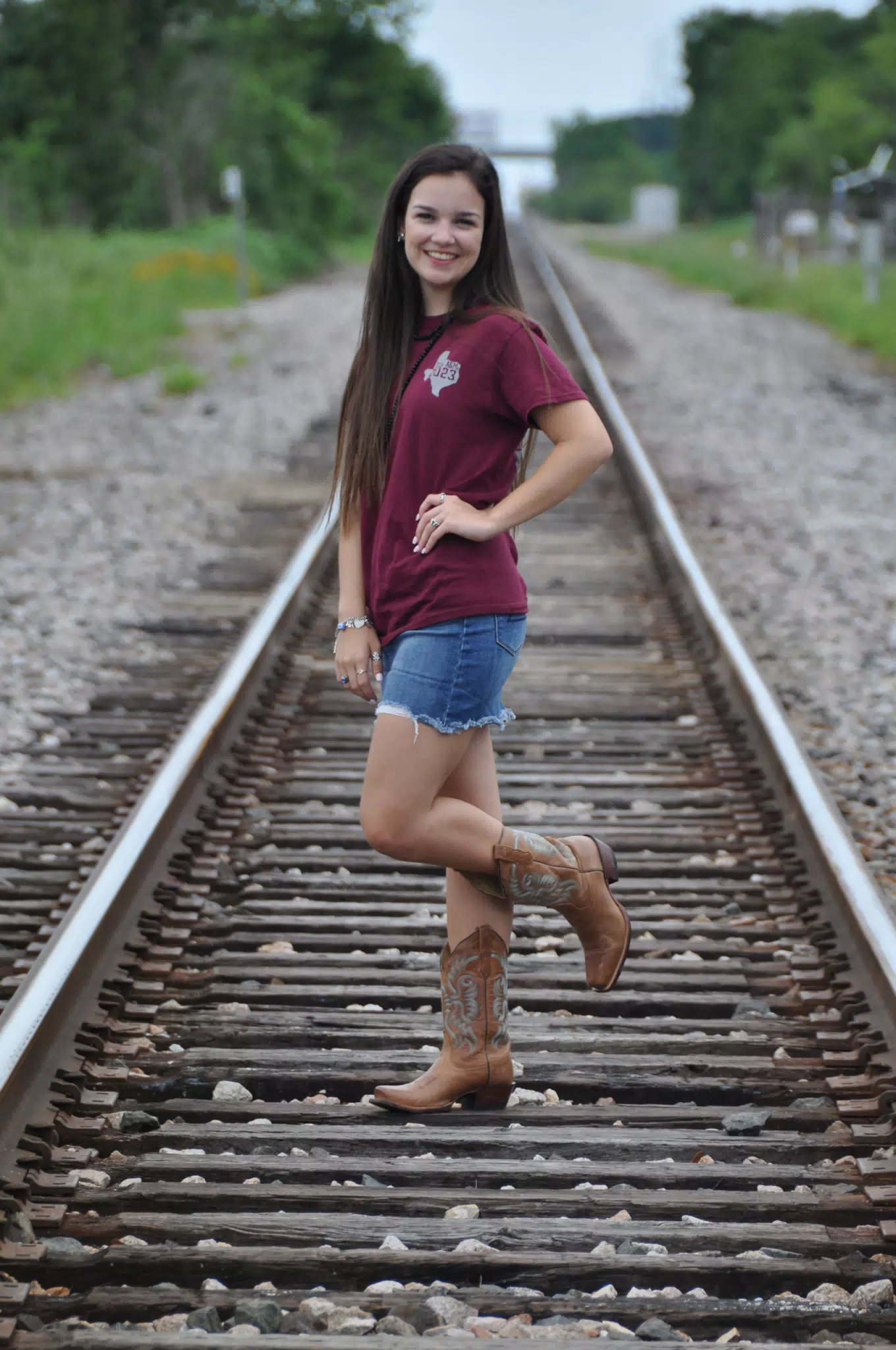 Model on One Foot in Train Tracks in Miniskirt