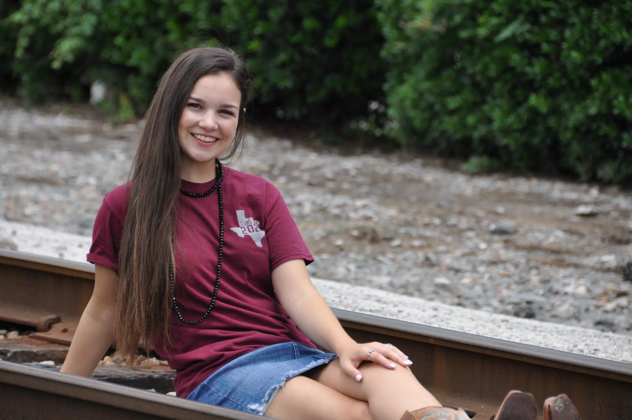 Smiling Teen on Railroad Tracks