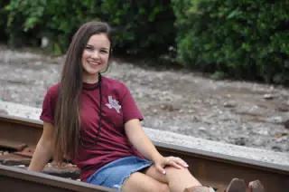 Smiling Teen on Railroad Tracks