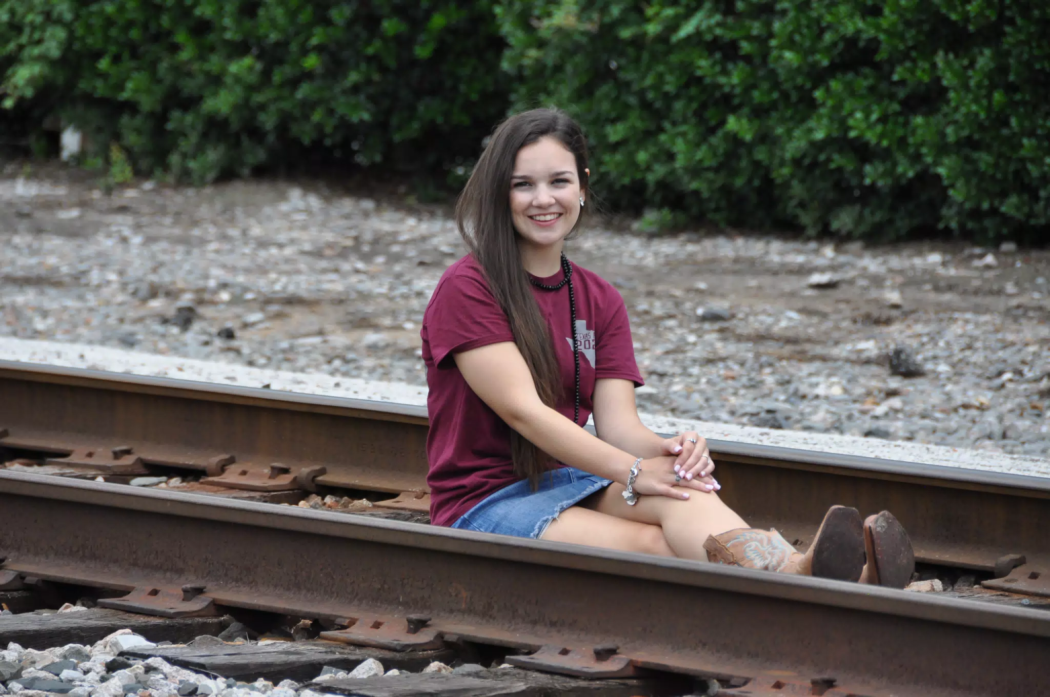 Teen Model in Jean Mini Skirt Sitting on Railroad Tracks