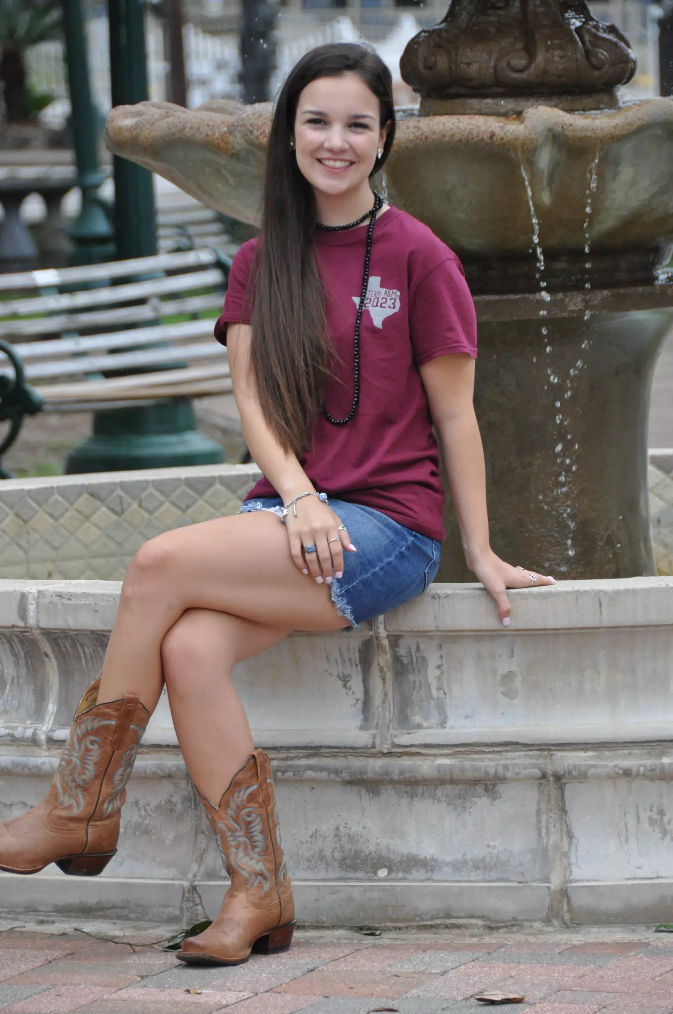 Girl in Jean Skirt and Cowboy Boots on Fountain