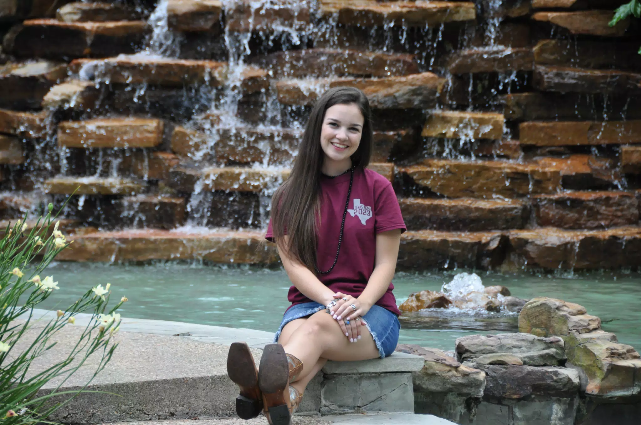 Brunette Teen Model in Denim Skirt and Cowboy Boots in Front of Waterfall in Galveston, Texas