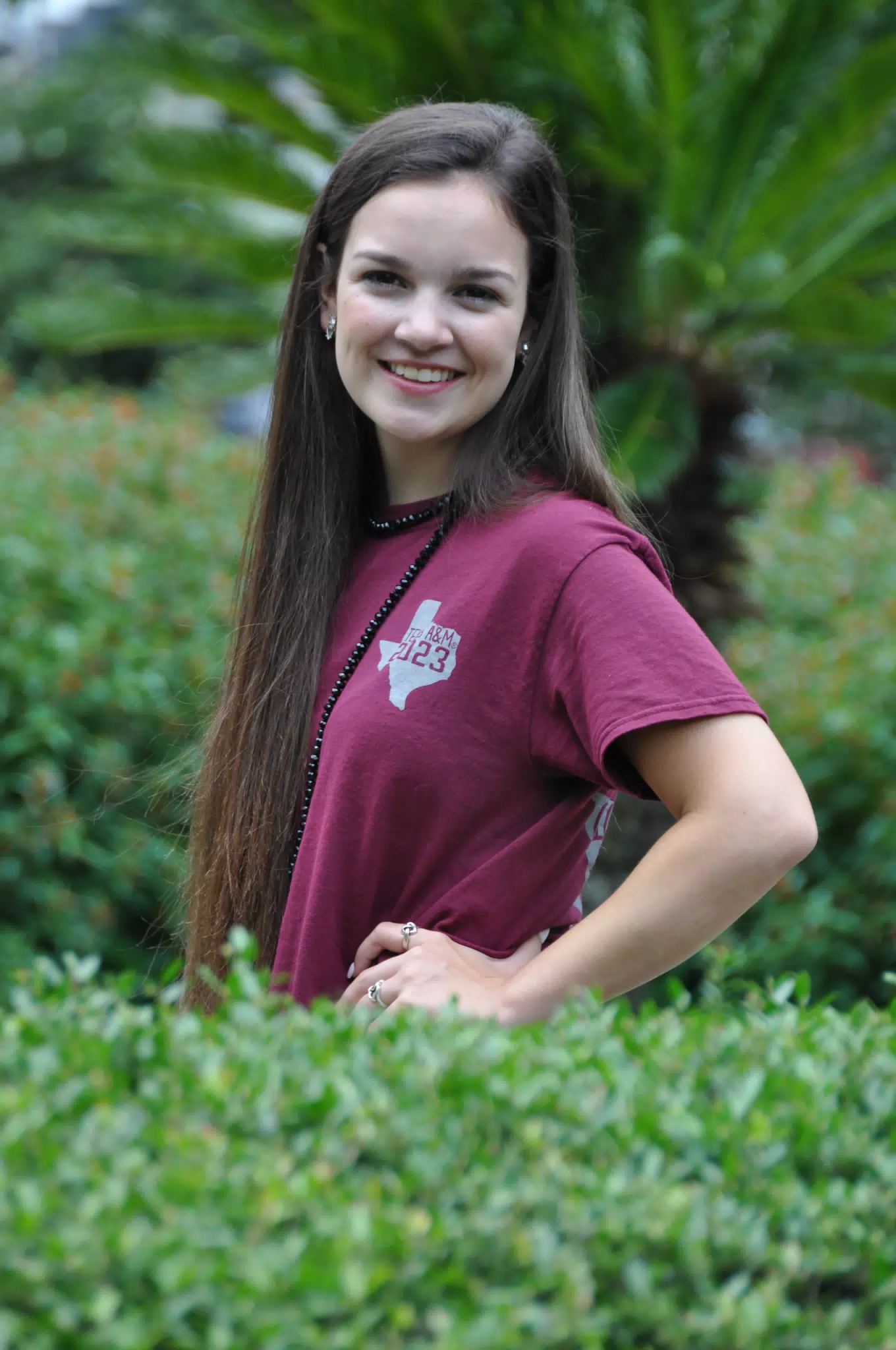 Smiling Brunette Model in Green Hedge Row in Texas