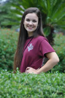 Smiling Brunette Model in Green Hedge Row in Texas