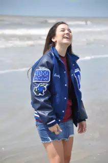 Teen Model Laughing on Galveston Beach in Letterman Jacket and Miniskirt