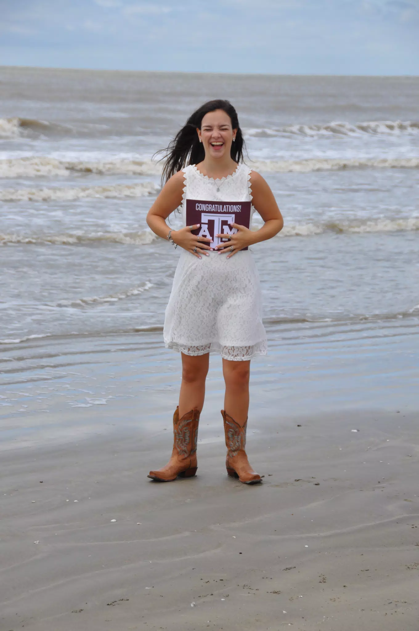 Teen in White Dress Laughing on Beach Holding Texas A&M Sign