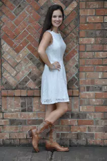 Teen in White Dress and Boots by Brick Wall Texas