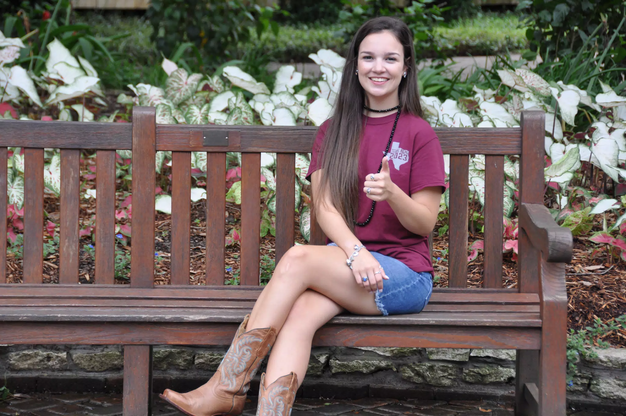 Emily Giving Thumbs Up on Bench in Park