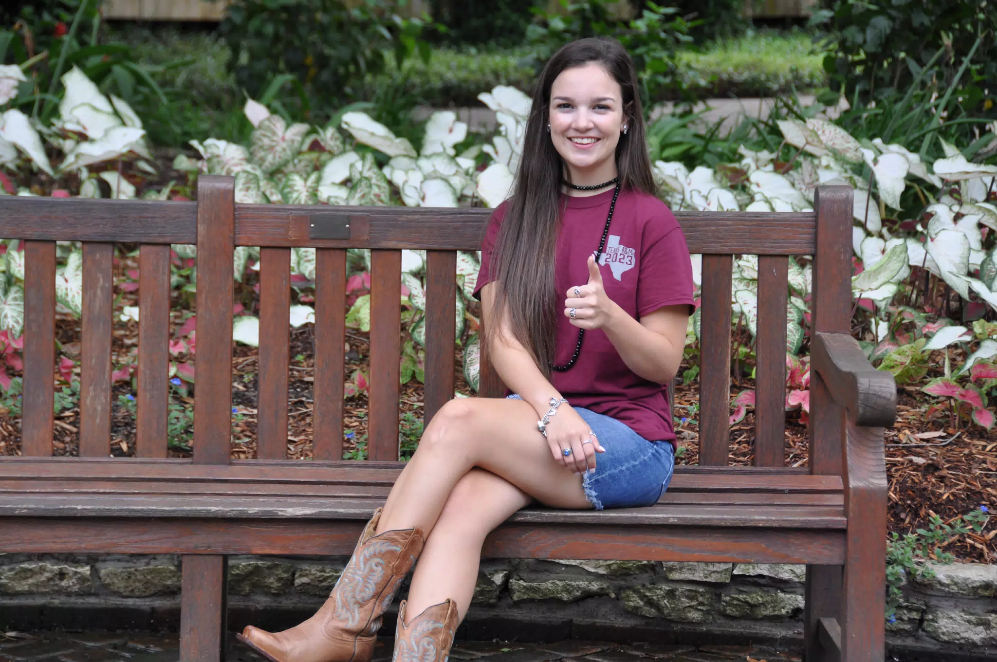 Emily on Park Bench in Skirt and Boots Thumbs Up