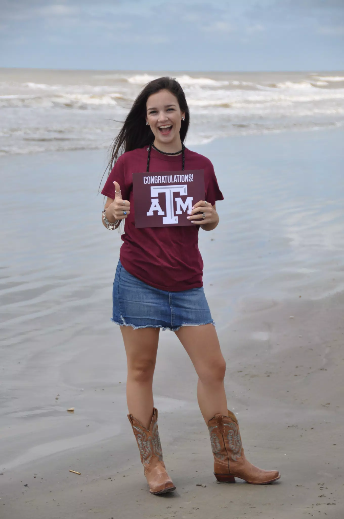Model Thumbs Up on Galveston Beach in Boots and Skirt