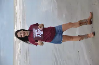 Model Thumbs Up on Galveston Beach in Boots and Skirt