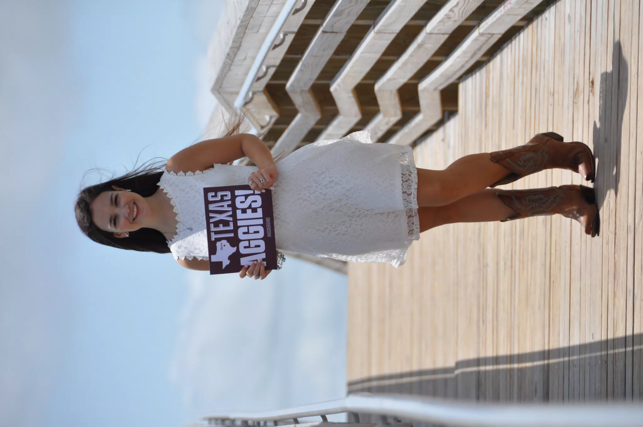 Emily in White on Galveston Boardwalk with Aggies Sign