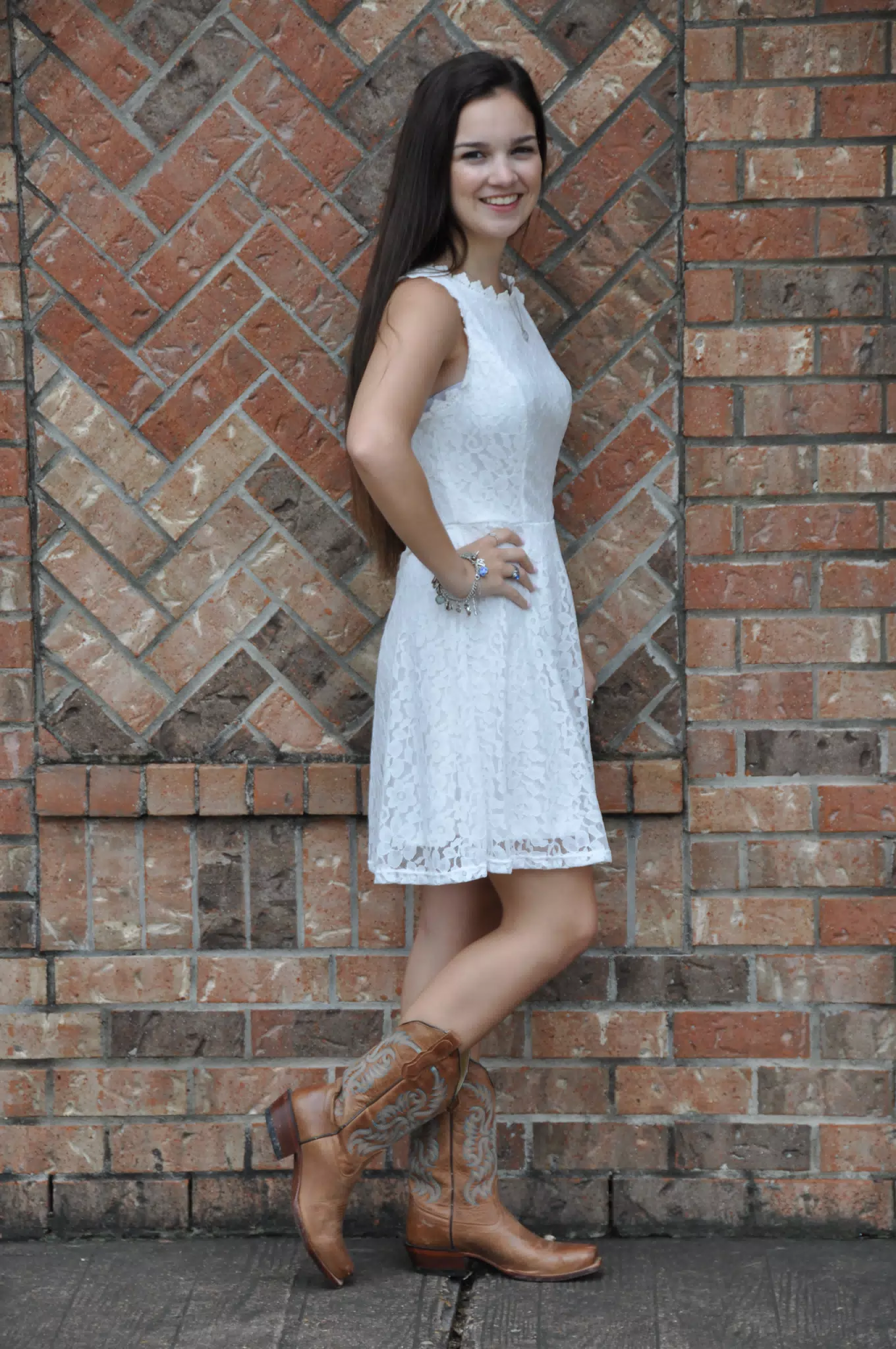 Brunette Model Standing by Brick Wall in Cowboy Boots