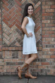 Brunette Model Standing by Brick Wall in Cowboy Boots