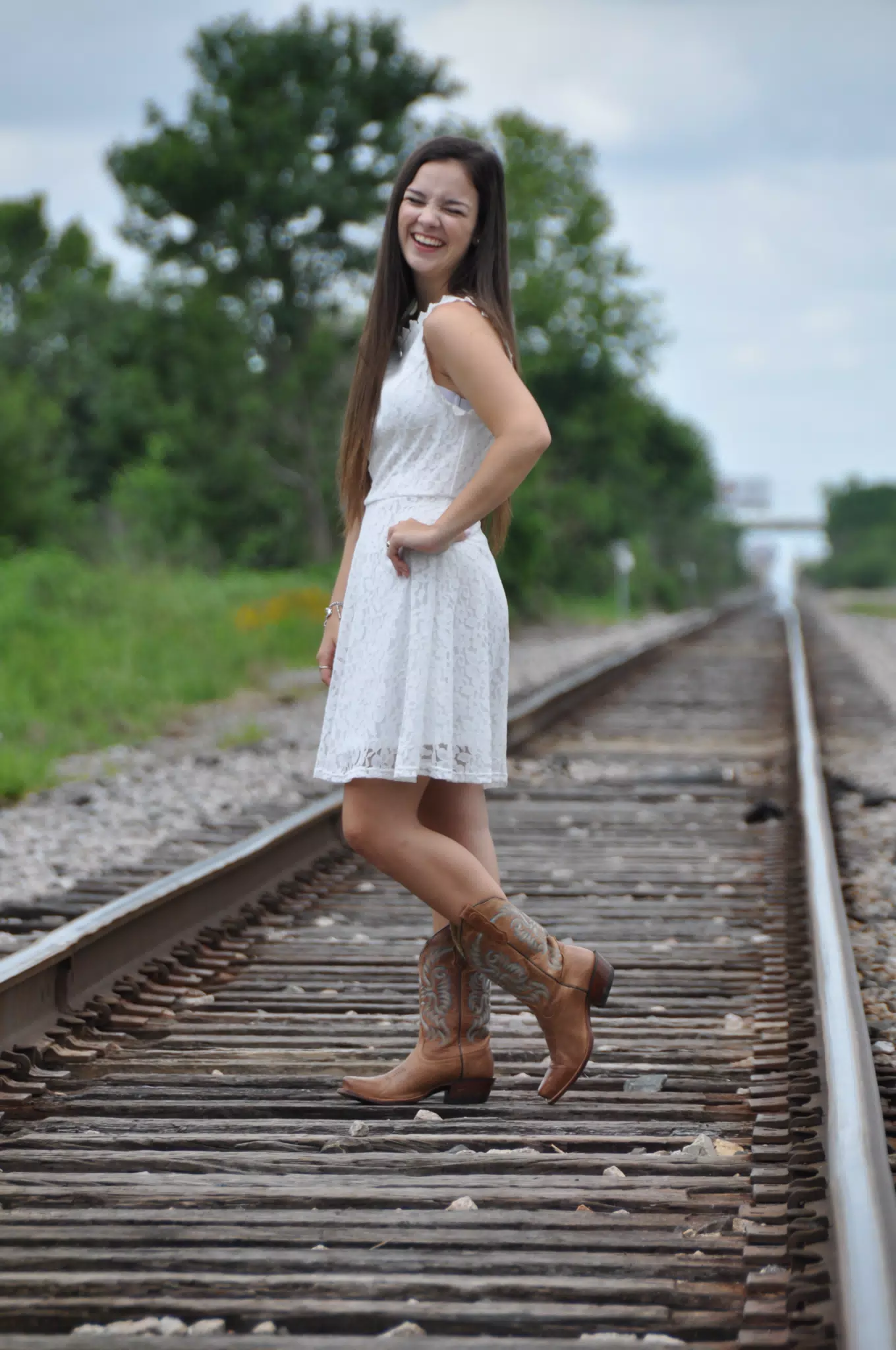 Laughing Brunette Model in White Dress and Cowboy Boots