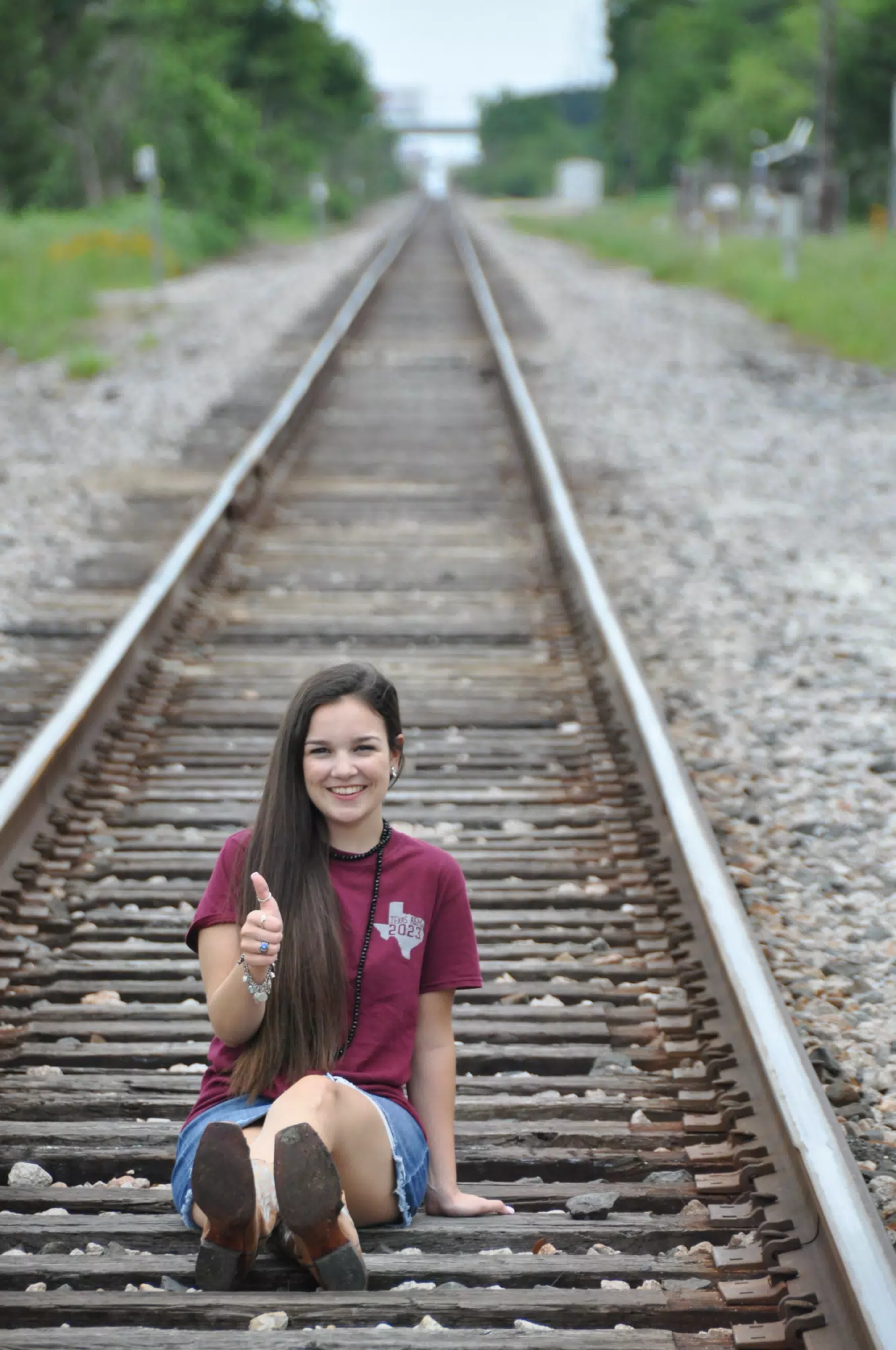 Brunette in Cowboy Boots on Railroad Tracks