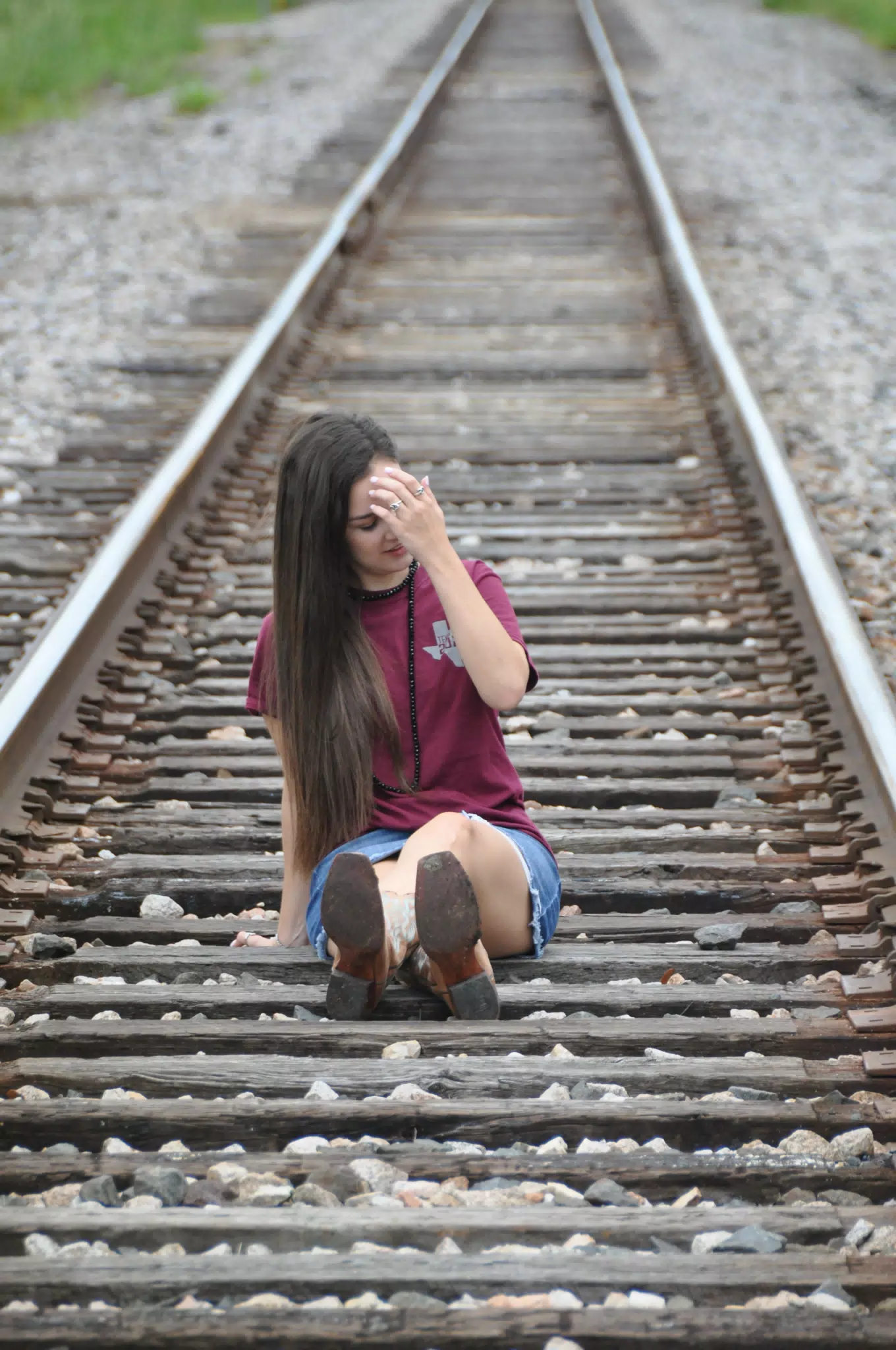 Model Adjusting Hair During Photoshoot on Railroad Tracks