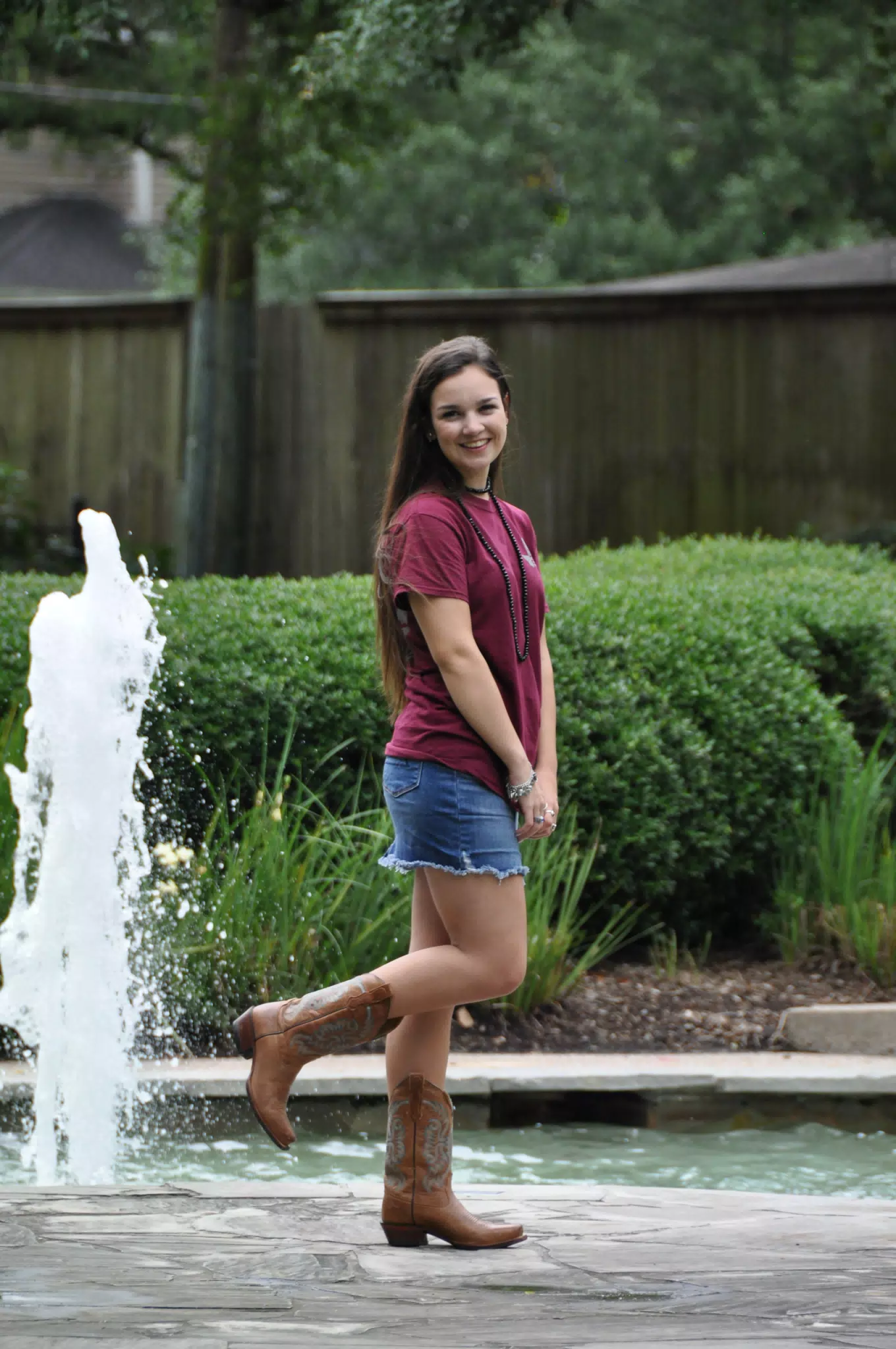Pretty Brunette Teen Model on One Foot in Denim Skirt by Fountain