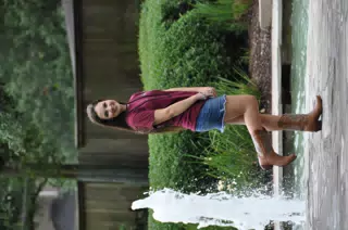 Pretty Brunette Teen Model on One Foot in Denim Skirt by Fountain