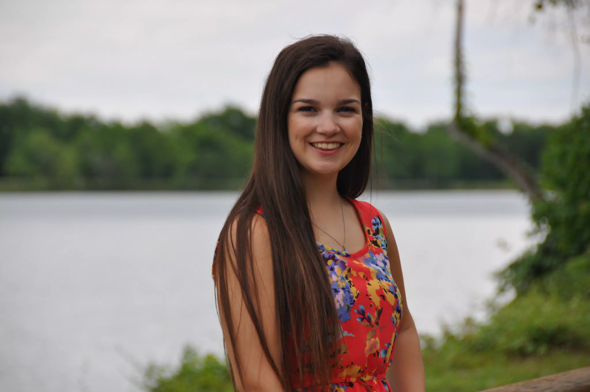 Emily Smiling in Red Dress by Pond
