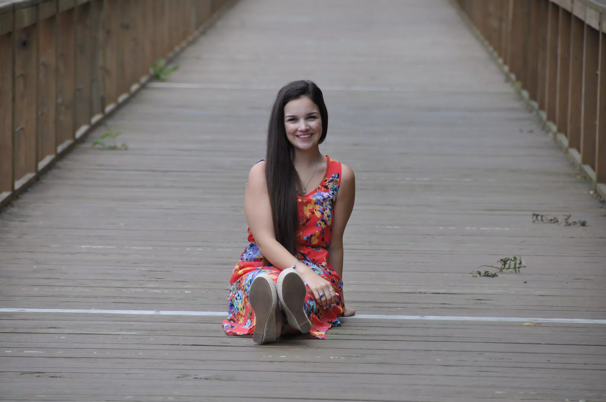 Model in Red Dress on Boardwalk Sitting