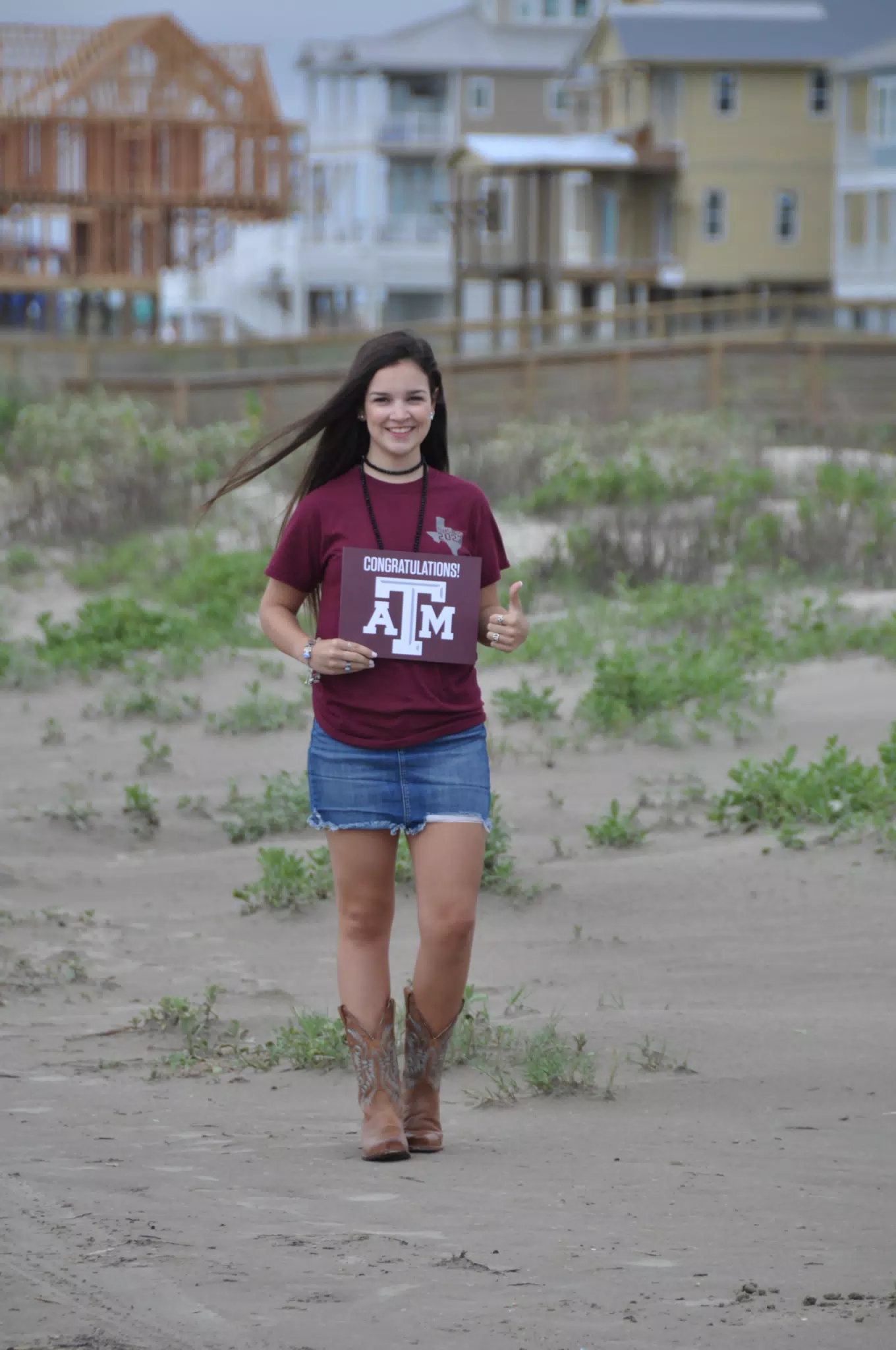 Emily with Texas A&M SIgn on Galveston Beach