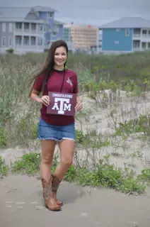 Emily with Texas A&M Sign on Galveston Beach