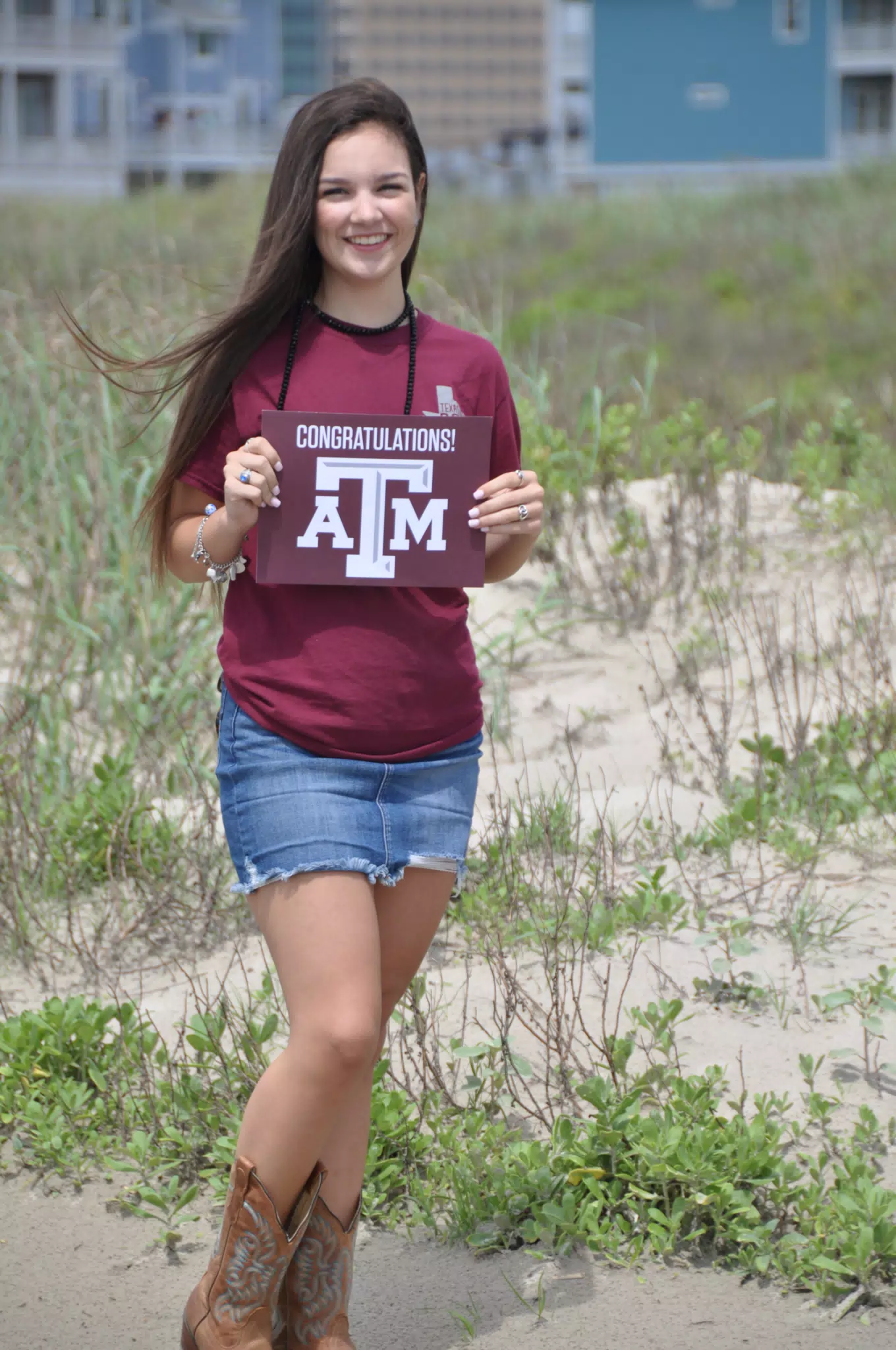 Emily with Aggies Sign on Galveston Beach