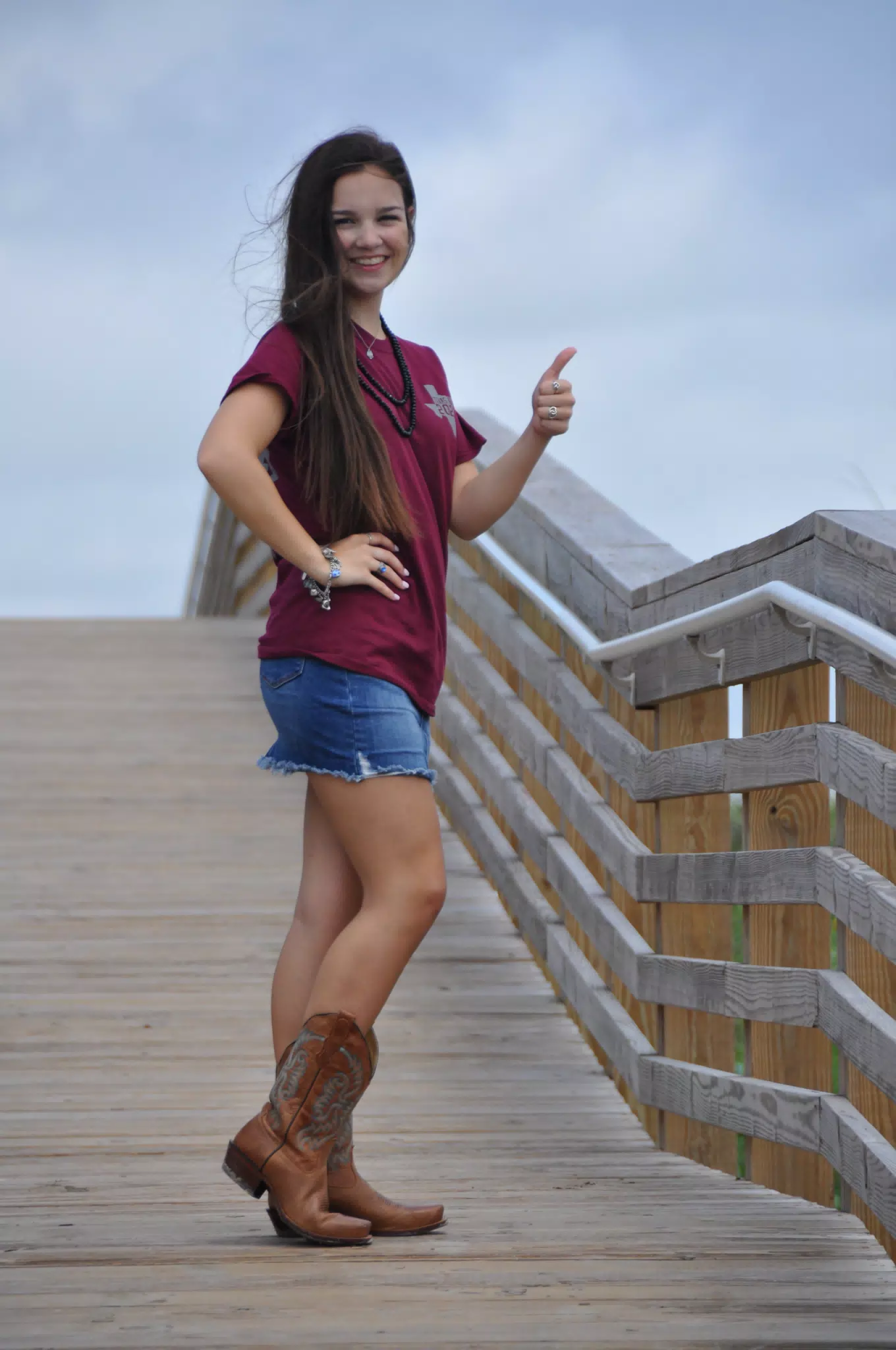 Emily Thumbs Up and Hand on Hip in Boots and Skirt on Galveston