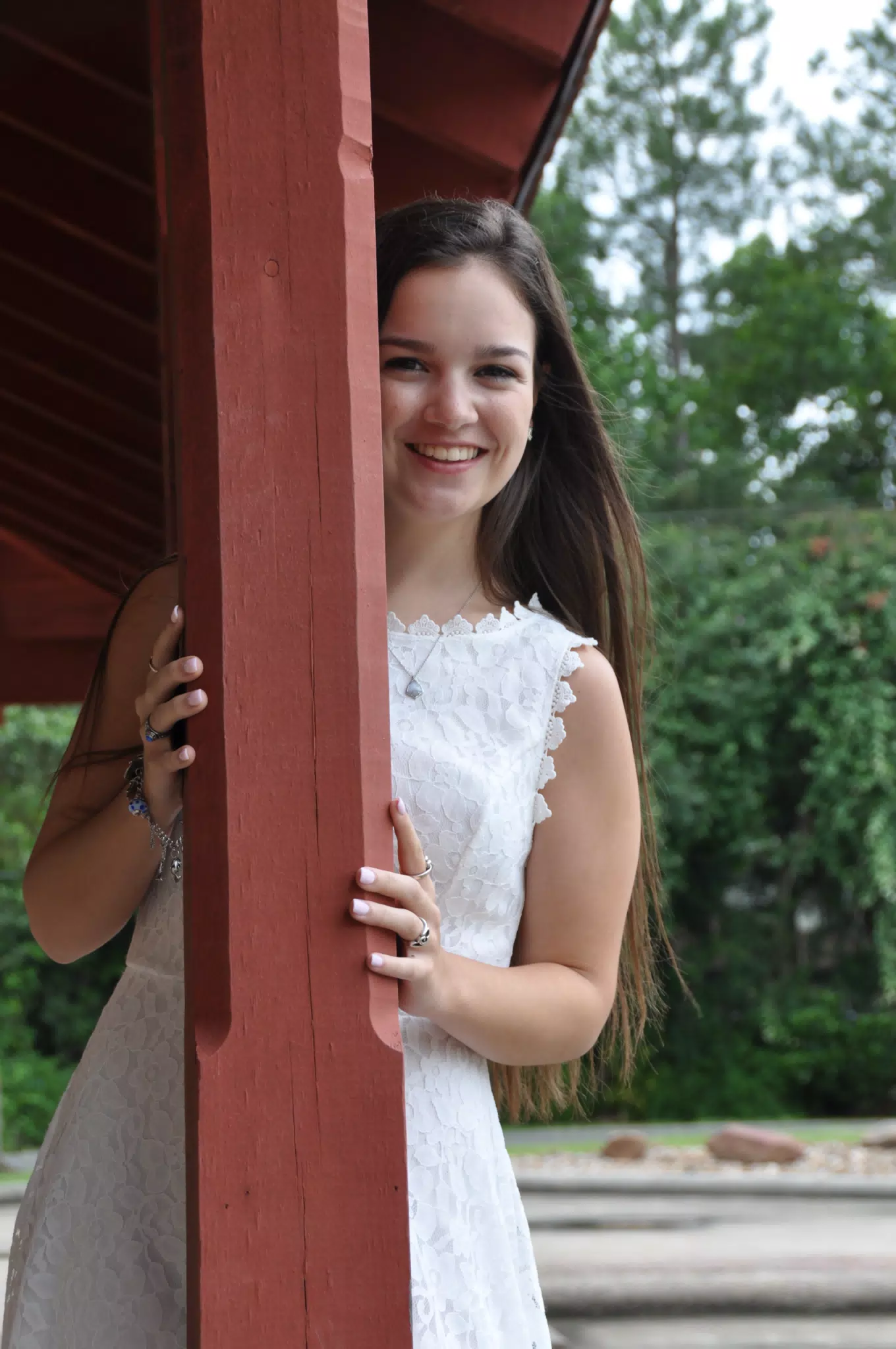 Brunette Teen Model in White Dress Behind Post Smiling